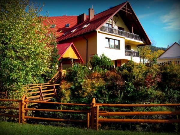 une grande maison avec une clôture devant elle dans l'établissement D.W. Lidia, à Korbielów