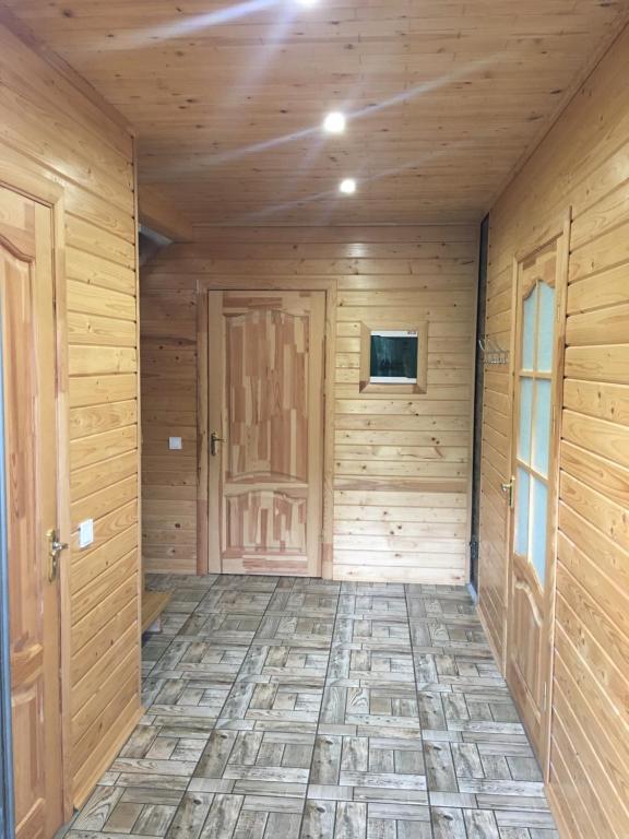 una stanza vuota con pareti in legno e una porta di Котедж Mountain house a Jaremče