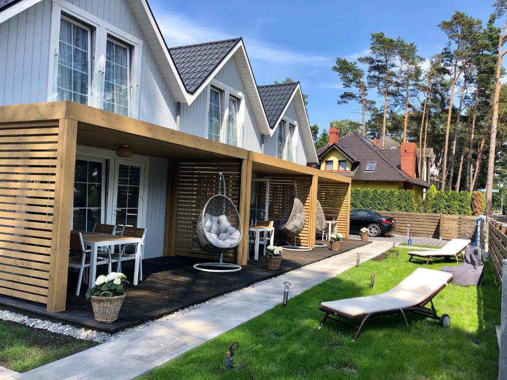 una casa con terraza con mesa y sillas en Baltic Sky, en Pobierowo