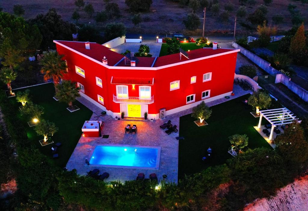 an aerial view of a red house with a pool at Casal da Rita Natura in Santarém