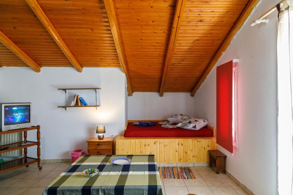 Habitación con cama, TV y techos de madera. en Ρήγας: Όμορφα στο Μεσολόγγι. Δ2 en Mesolongion
