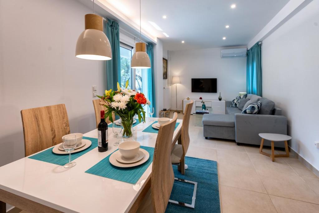 - une salle à manger et un salon avec une table et des chaises dans l'établissement Lux 1-bedroom apartement next to the sea in Voula, à Athènes
