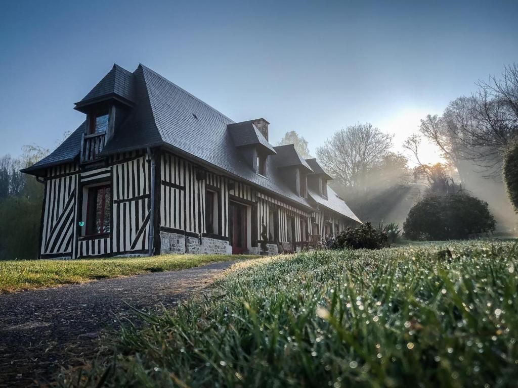 een oud huis met een zwart-wit gebouw bij L'Herbe Haute in Honfleur