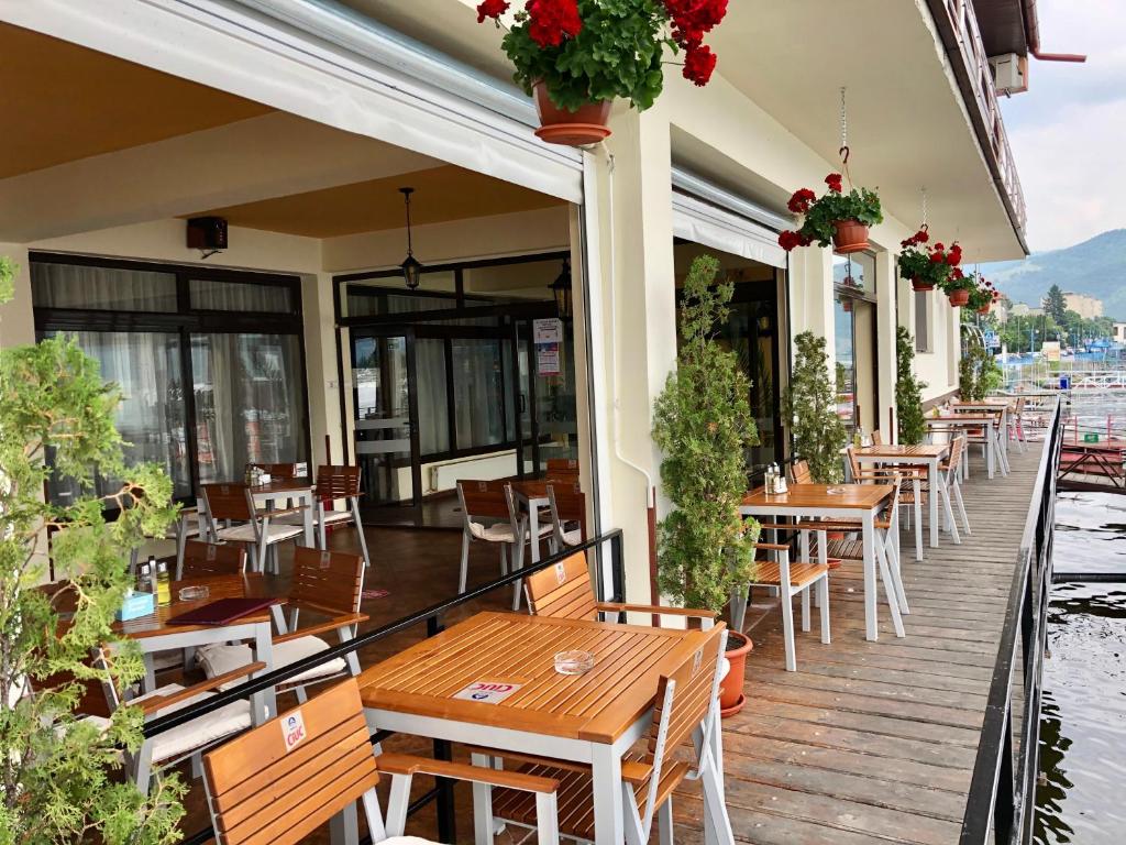 un restaurante con mesas de madera y sillas en una terraza en Pensiunea Damiro, en Orşova