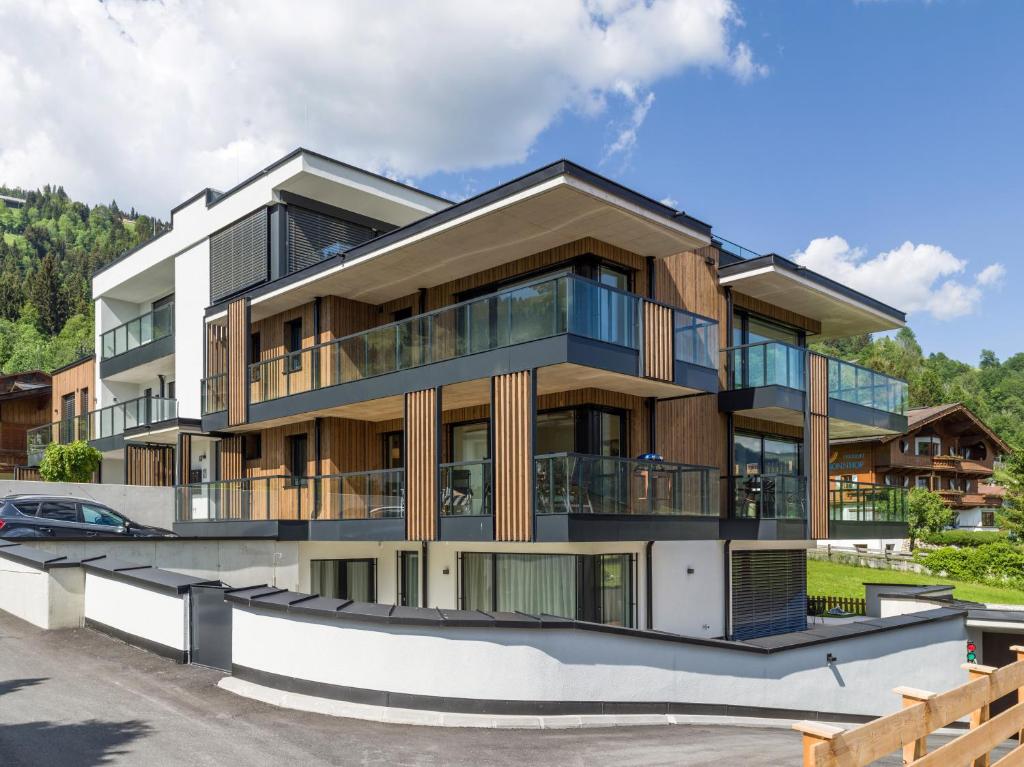 um edifício de apartamentos com varandas e um parque de estacionamento em Appartment am Sonnberg em Brixen im Thale