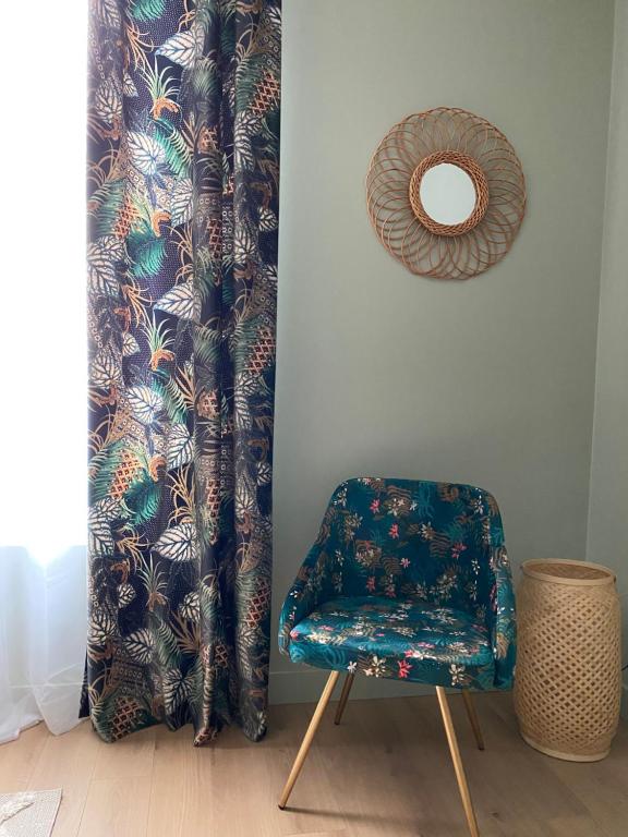 a chair sitting next to a wall with a curtain at Villa st Louis 2 in Cabourg