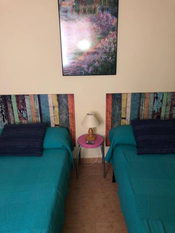 Habitación con 2 camas y mesa con lámpara. en Apartamento climatizado con wifi Mar Menor, en San Pedro del Pinatar