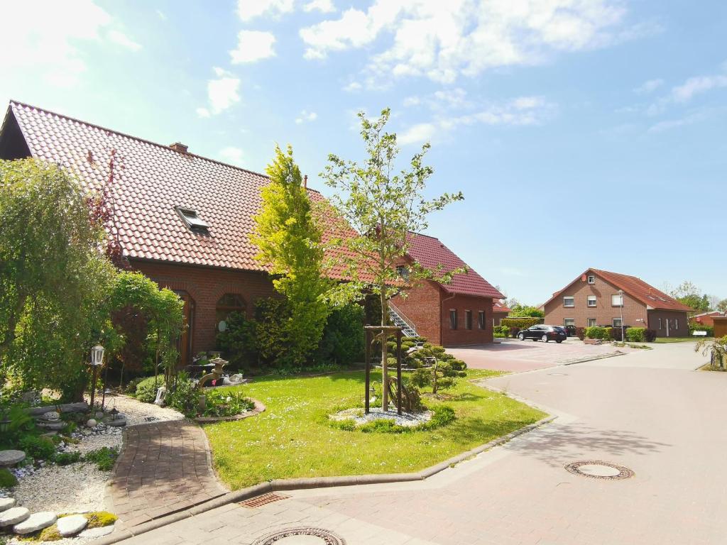 een huis met een boom in de tuin bij Steuerbord in Neuharlingersiel