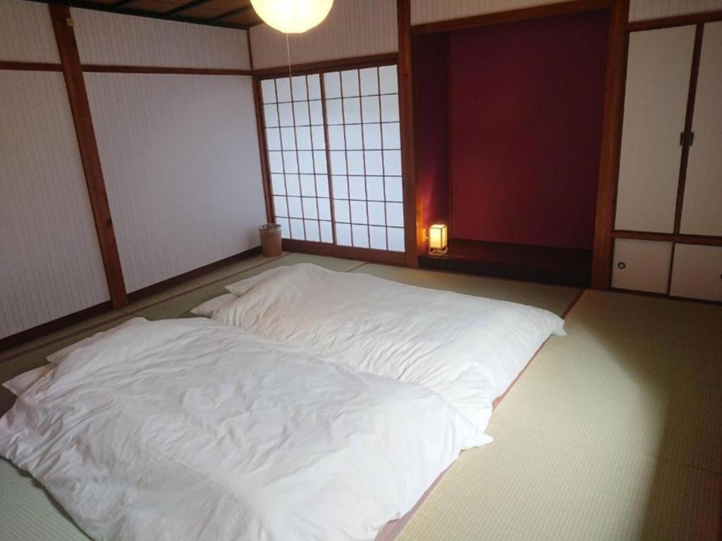 a large white bed in a room with windows at KINOSAKI KNOT - Vacation STAY 83611 in Toyooka