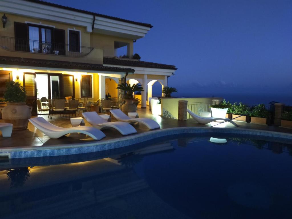 a villa with a swimming pool at night at Villa Fontana Saia in Paola