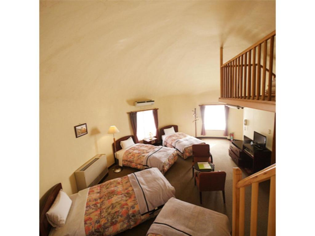 Habitación de hotel con 3 camas y escalera en TOKINOSUMIKA HOTEL OLIVE NO KI - Vacation STAY 83624, en Izu