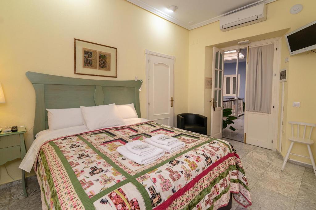 a hotel room with a bed with a bedspread at Casa Patio del Panadero in Cádiz