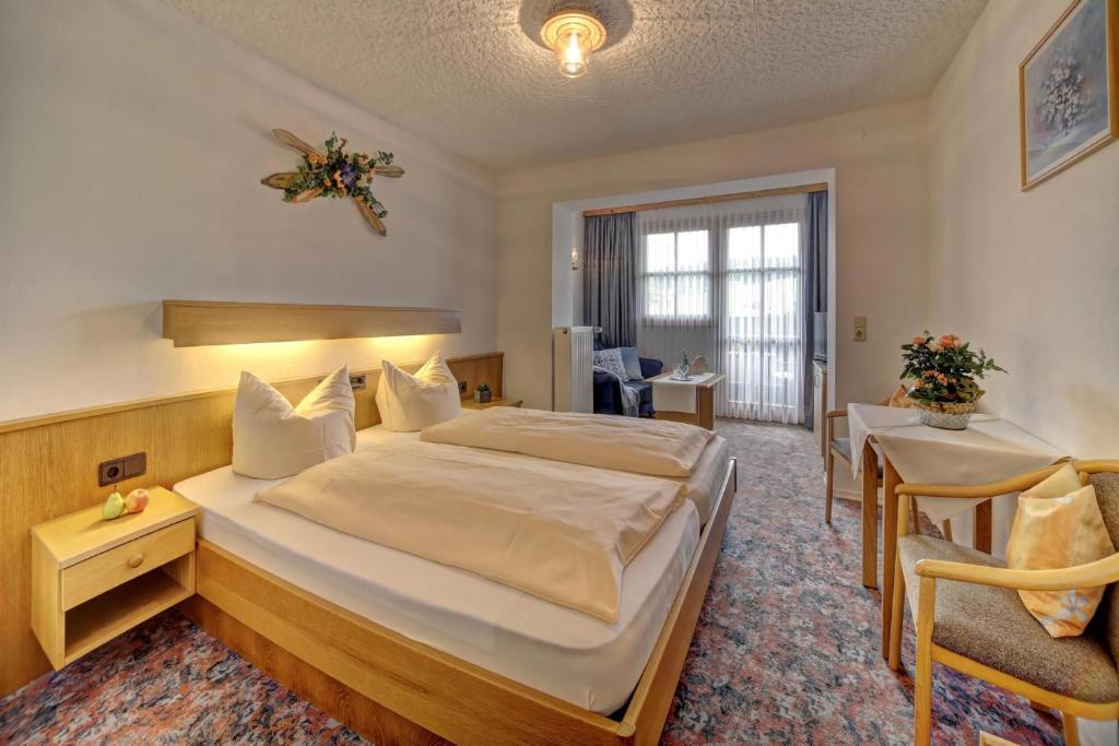 ein Hotelzimmer mit einem großen Bett und einem Schreibtisch in der Unterkunft Ferienhotel Kollmerhof in Rimbach