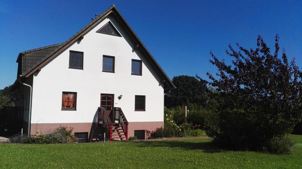 a white house with a black roof at Gartenblick in Lütow