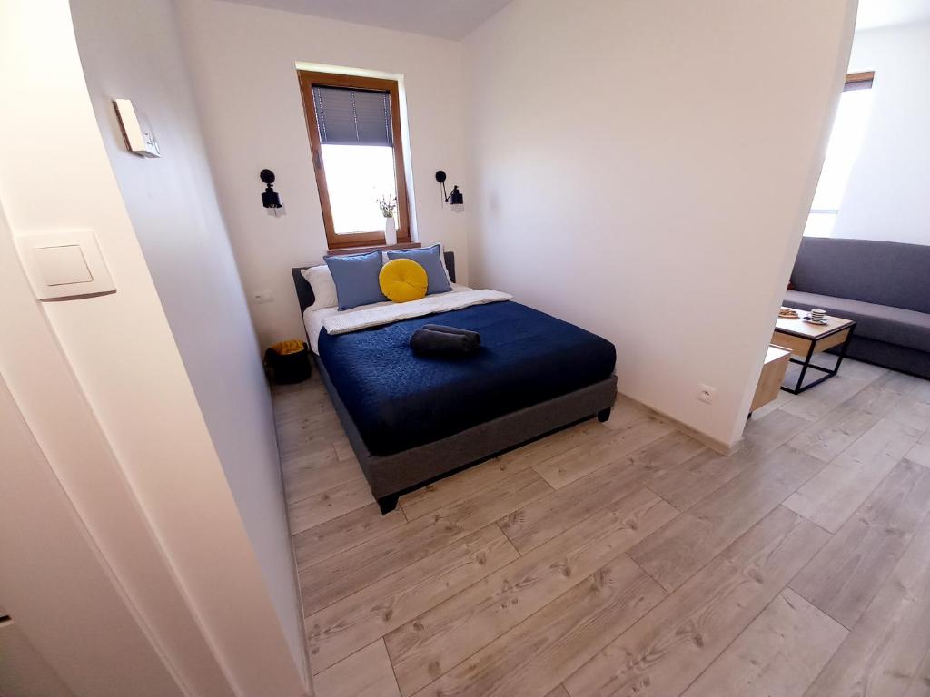 małą sypialnię z łóżkiem i lustrem w obiekcie BALT Marynarska 8 w Sarbinowie