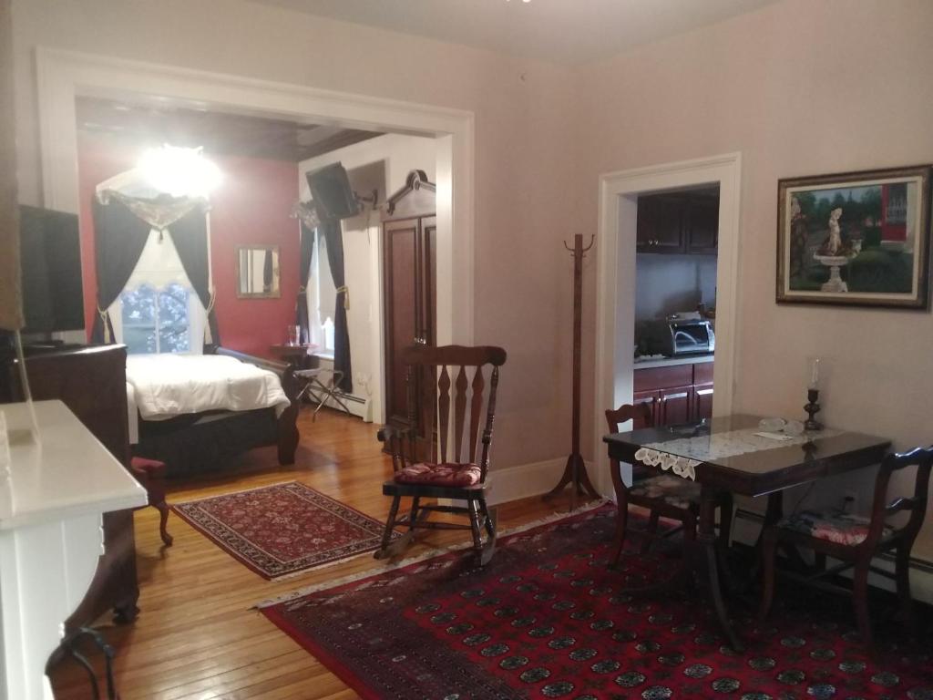 a living room with a dining table and a bedroom at Stay Saratoga in Saratoga Springs