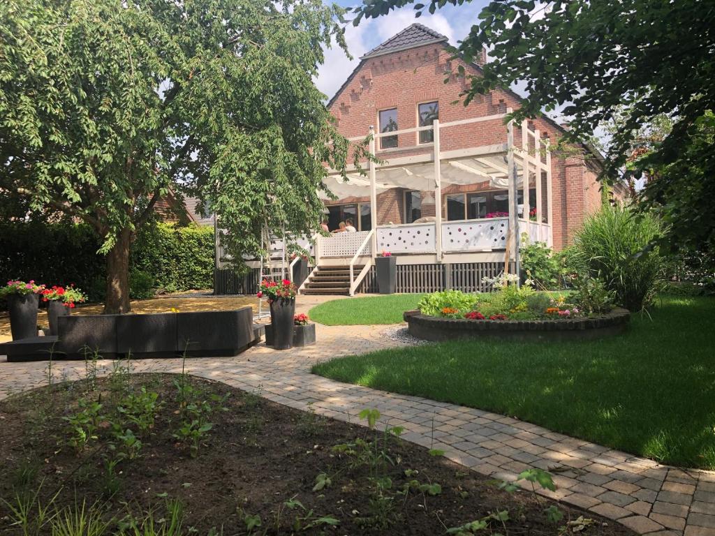 une maison en briques avec un jardin en face de celle-ci dans l'établissement B&B Reveille, à Clèves