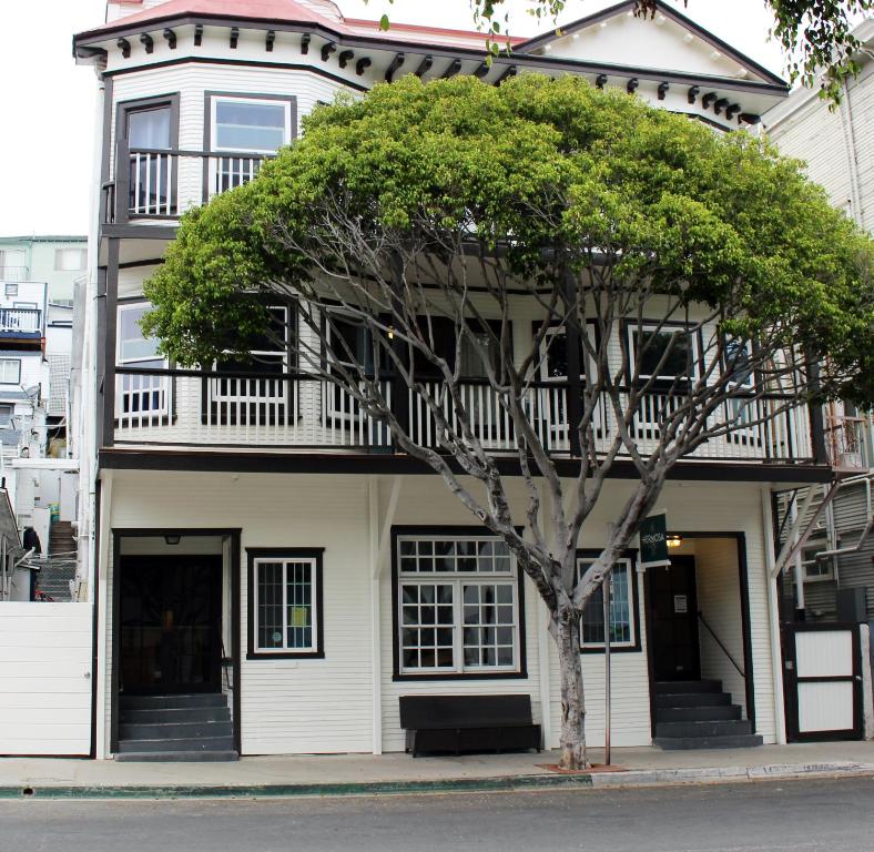 Una casa blanca con un árbol delante. en Hermosa Hotel, en Avalon