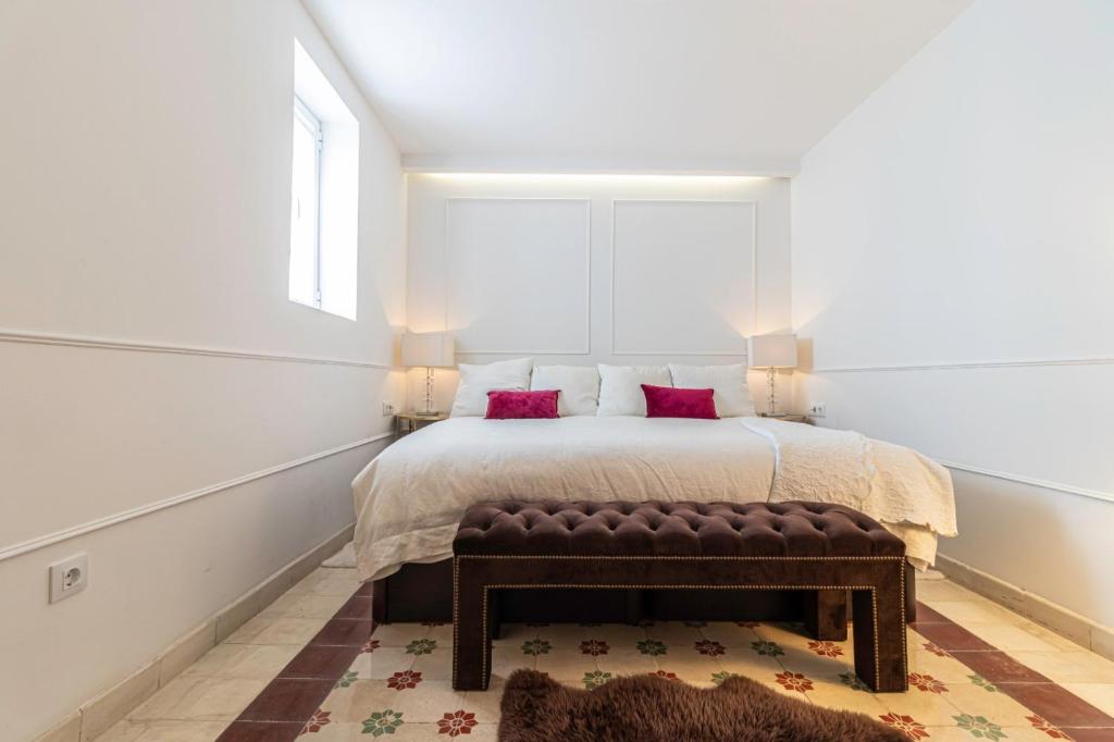 1 dormitorio con 1 cama con sofá de cuero marrón en Casa Palacio MoMa - Centro - Parking opcional, en Jerez de la Frontera
