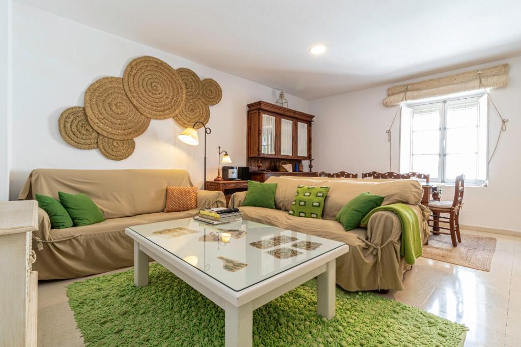 ein Wohnzimmer mit einem Sofa und einem Tisch in der Unterkunft Casa MNueLa - Centro Jerez - Parking opcional in Jerez de la Frontera