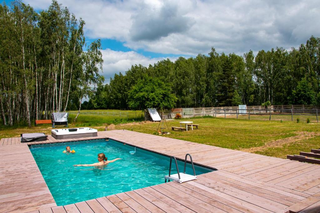 Eine Frau im Pool im Garten. in der Unterkunft Nowa Wola 58 - 200qm appartment in a small village, with pool, sauna and big garden in Rusiec