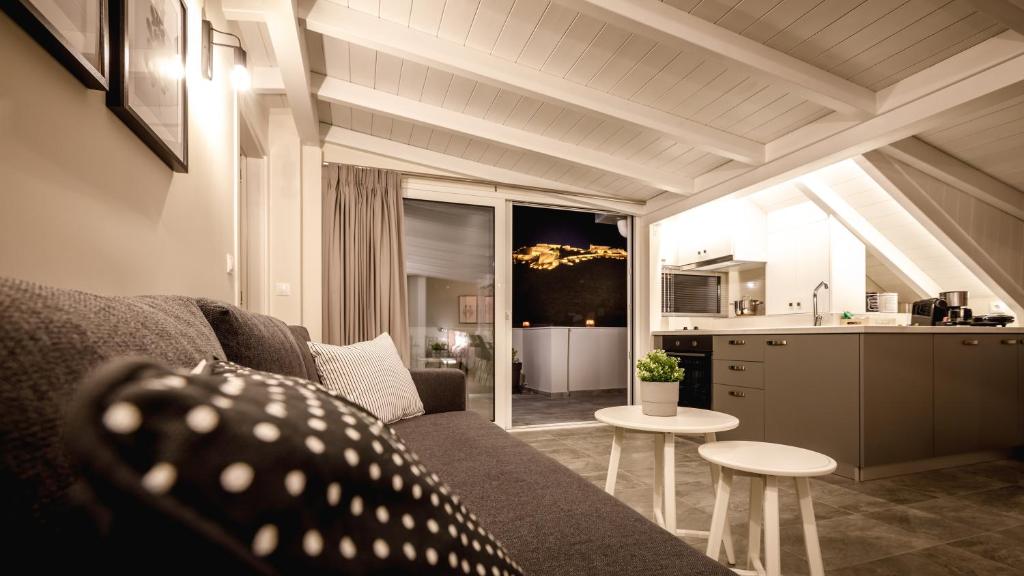 ナフプリオにあるGMA - Luxury Loft Nafplioのリビングルーム(ソファ、テーブル付)、キッチンが備わります。