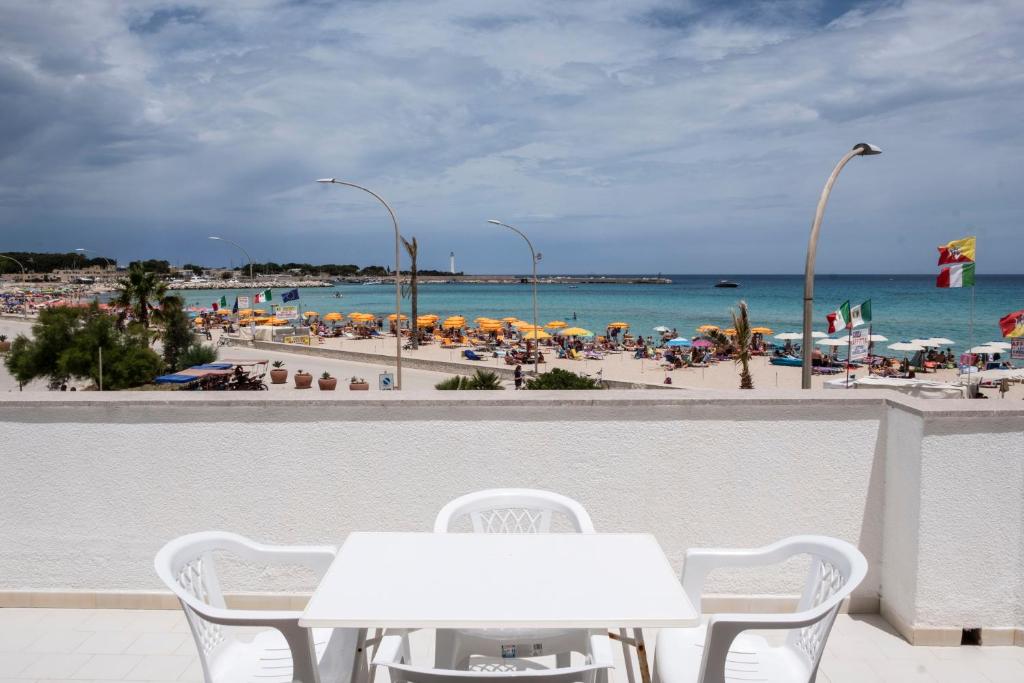 a view of a beach with two tables and chairs at Casa Azzurra sul mare e centralissima in San Vito lo Capo