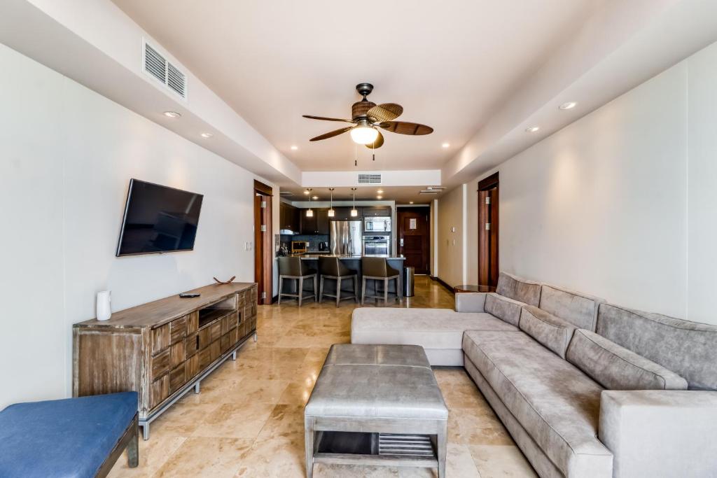 a living room with a couch and a flat screen tv at Unit 1014 at Croc's in Jacó