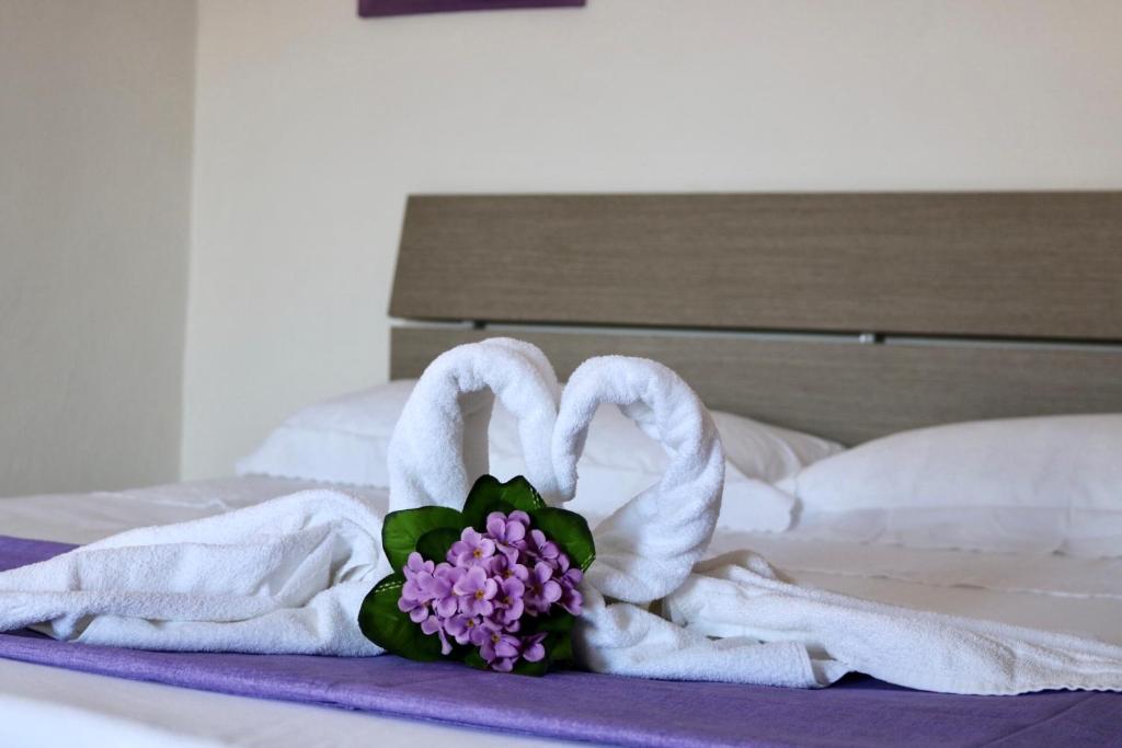 サン・ヴィート・ロ・カーポにあるCasa Vacanze Lillaのベッドの上にタオル2枚と花束