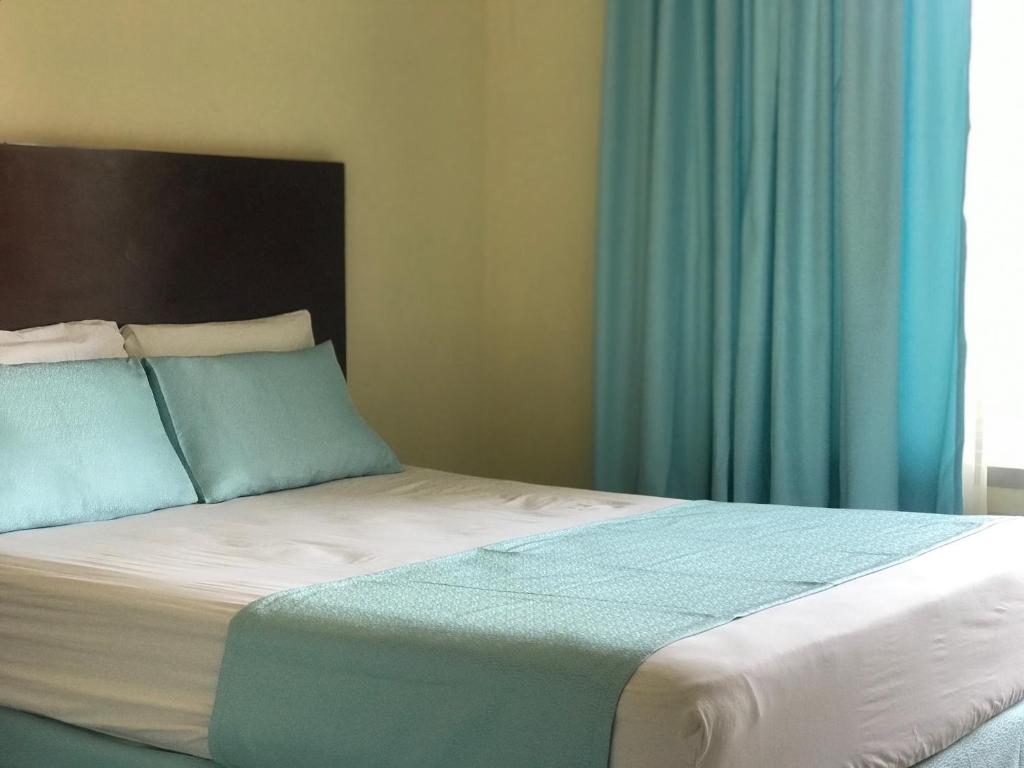 1 dormitorio con 1 cama grande y cortinas azules en Hotel Viru Viru II, en Santa Cruz de la Sierra