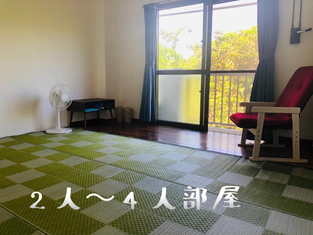 salon z krzesłem i oknem w obiekcie Minshuku Kuroshima w mieście Kuroshima