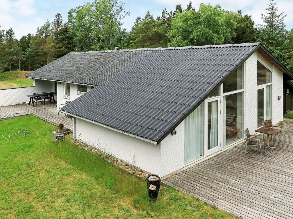 ブラーバンドにあるHoliday home Blåvand XVIの灰色の屋根とデッキのある家