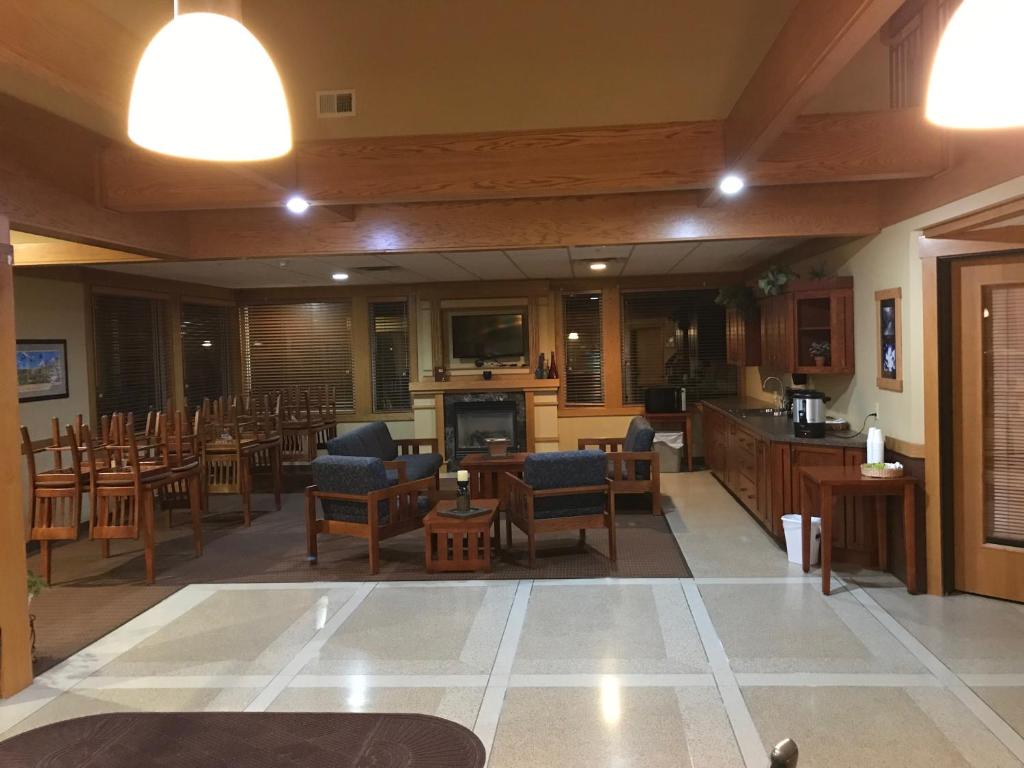 ein großes Zimmer mit Tischen und Stühlen sowie einer Küche in der Unterkunft Prairie Inn Holmen La Crosse Area in Holmen