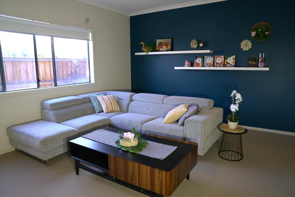 a living room with a couch and a coffee table at 6 Bedrooms Contemporary Big House at Pakenhem in Pakenham