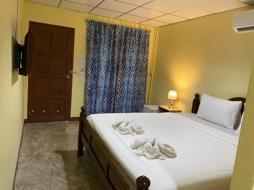 a bedroom with a bed with towels on it at Sasi Nonthaburi Hotel in Nonthaburi