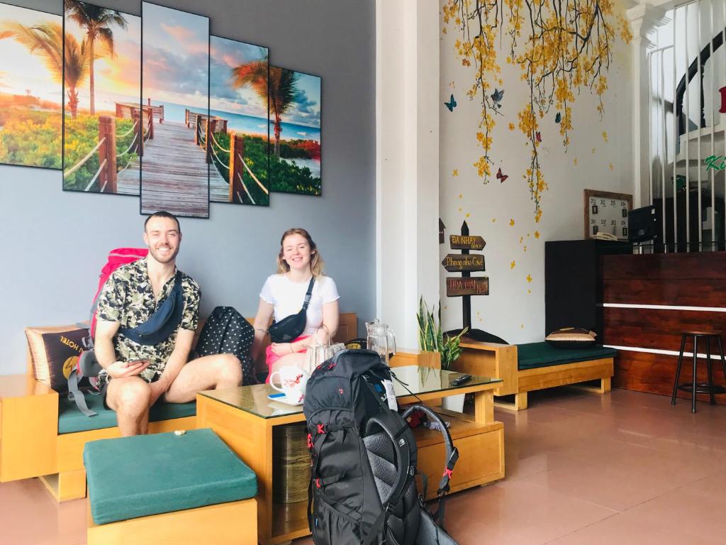 a man and woman sitting on a couch in a room at Hoa Mai Hotel in Dong Hoi