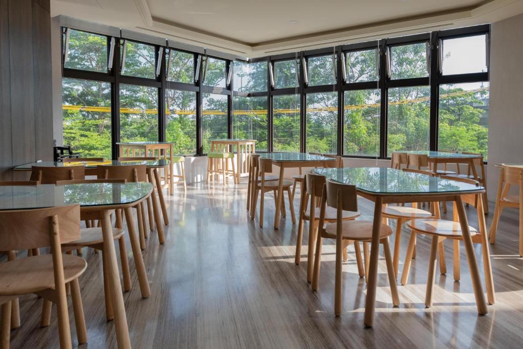 een kamer met tafels, stoelen en ramen bij MI YUE Boutque Motel in Taiping
