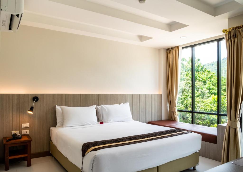 a hotel room with a bed and a window at Ozone Hotel Khao Yai in Mu Si