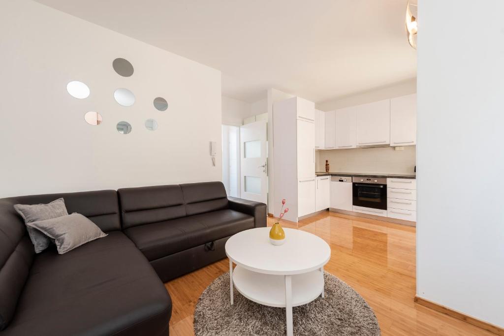 a living room with a black couch and a white table at Enna house with private jacuzzi in Novalja
