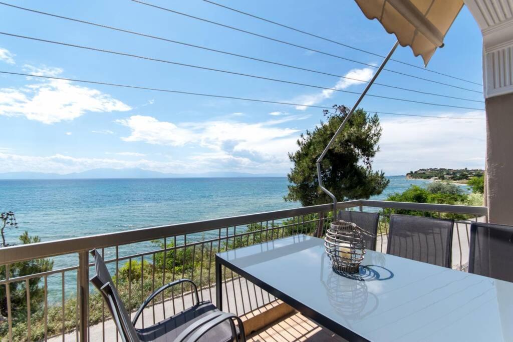 a table and chairs on a balcony with the ocean at Endless sea view house in Nea Irakleia