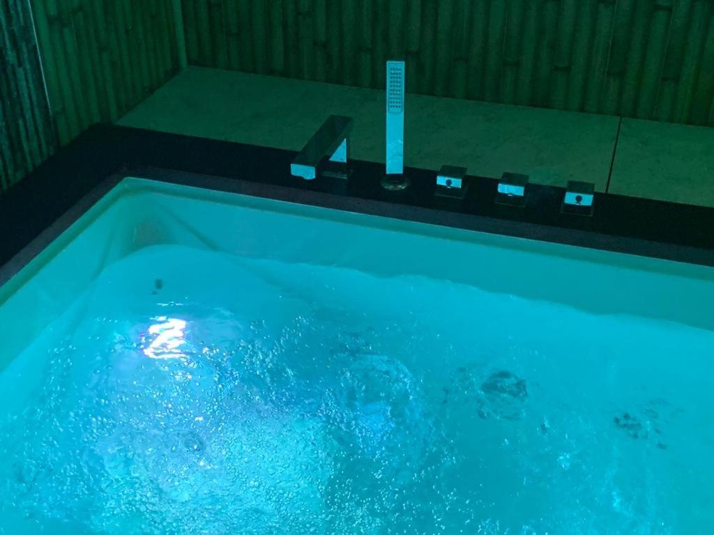 a bath tub filled with blue water in a bathroom at lolf with jacuzzi in malaga in Málaga