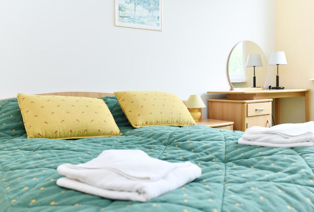 a blue bed with two towels on it at Apartament 14A in Kołobrzeg