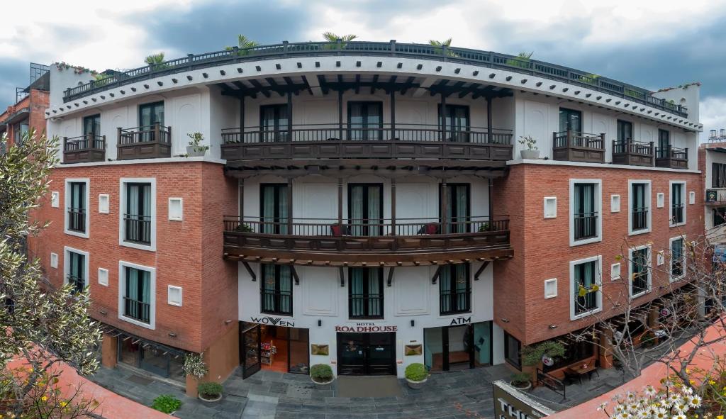 ein großes rotes Backsteingebäude mit einem Balkon in der Unterkunft Hotel Roadhouse in Kathmandu