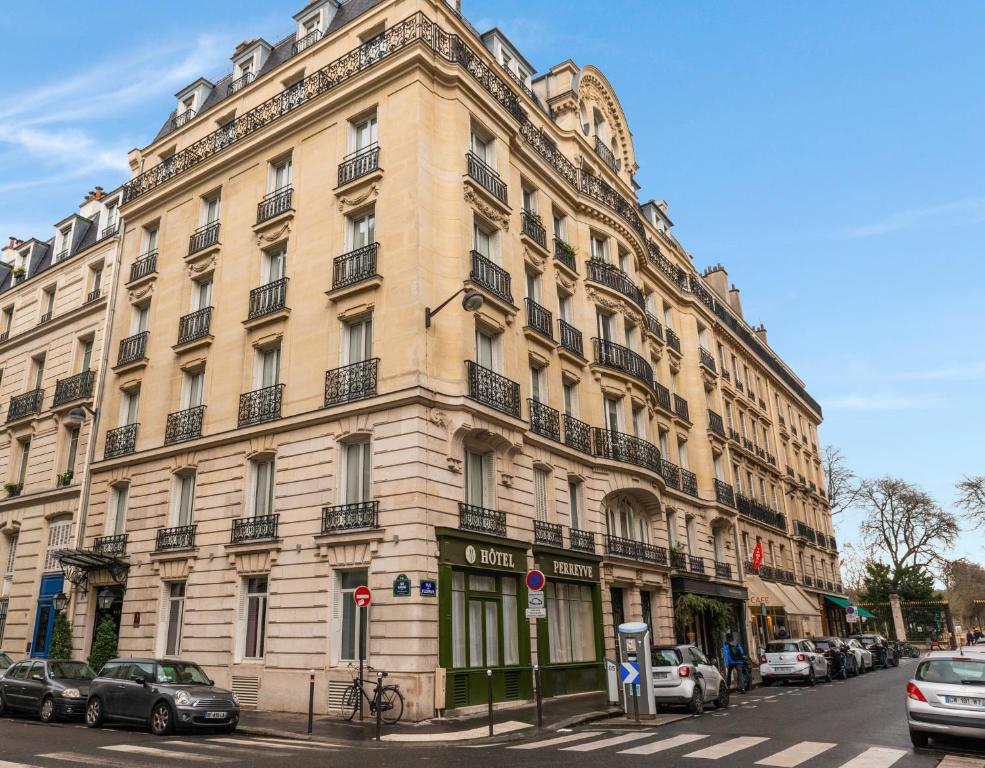 ein großes Gebäude mit davor geparkt in der Unterkunft Hôtel Perreyve - Jardin du Luxembourg in Paris