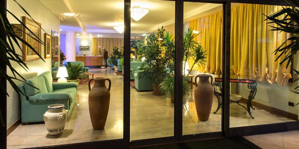 a lobby with vases on display in a building at Hotel Torresi in Potenza Picena