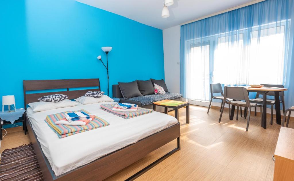 een slaapkamer met een bed en een blauwe muur bij Studio Koral in Soko Banja