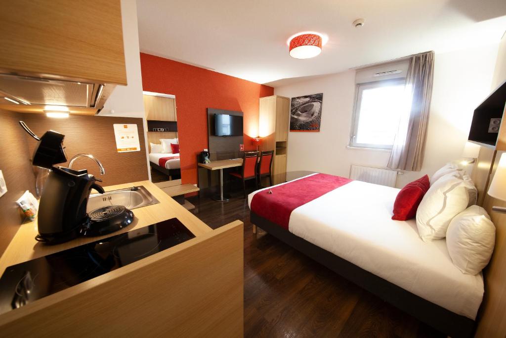 a hotel room with a couch, coffee table and a television at Apparthotel Privilodges Carré de Jaude in Clermont-Ferrand