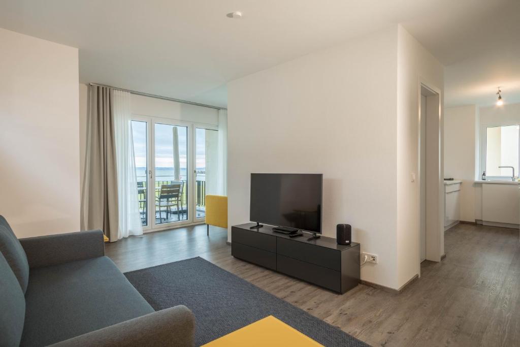 a living room with a couch and a flat screen tv at Ferienwohnung Montfort in Langenargen