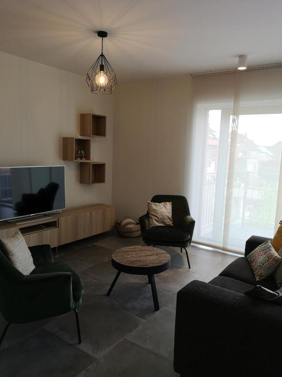 a living room with two chairs and a flat screen tv at Vakantiewoning Atuatuca in Tongeren