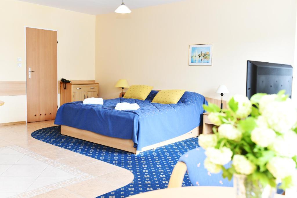 a bedroom with a blue bed and a tv at Apartament 14B in Kołobrzeg